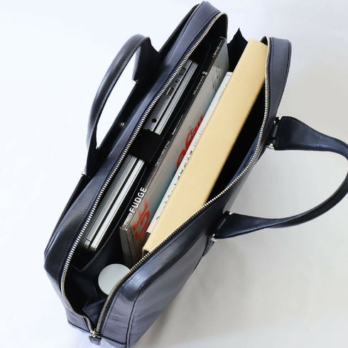 メイン収納は大きく開く三方開き仕様で、A4ファイル3冊、本、手帳、500mlペットボトル、折りたたみ傘などをスムーズに出し入れでき、小物ポケットやペン差し、大きめのファスナーポケットに加え、クッション材入りのPC収納ポケットも備えています。